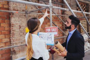 young-real-estate-agents-with-scaffold-background
